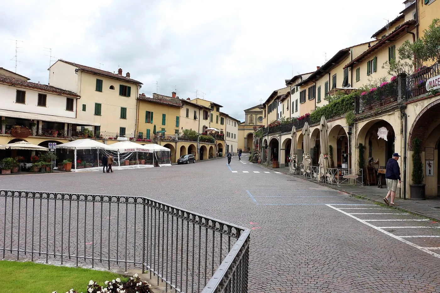 The sloping square of Greve in Chianti, with arcaded houses on one side and restaurant awnings on the other