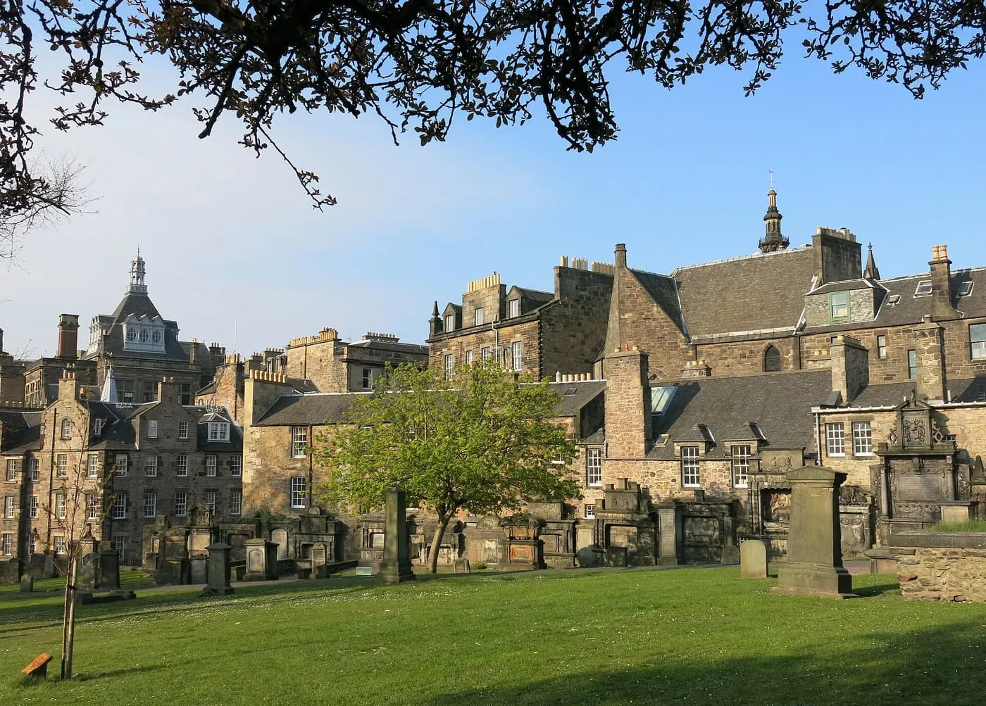 Old monuments in Greyfriars Kirkyard with the stone buildings and spires of the Old Town behind