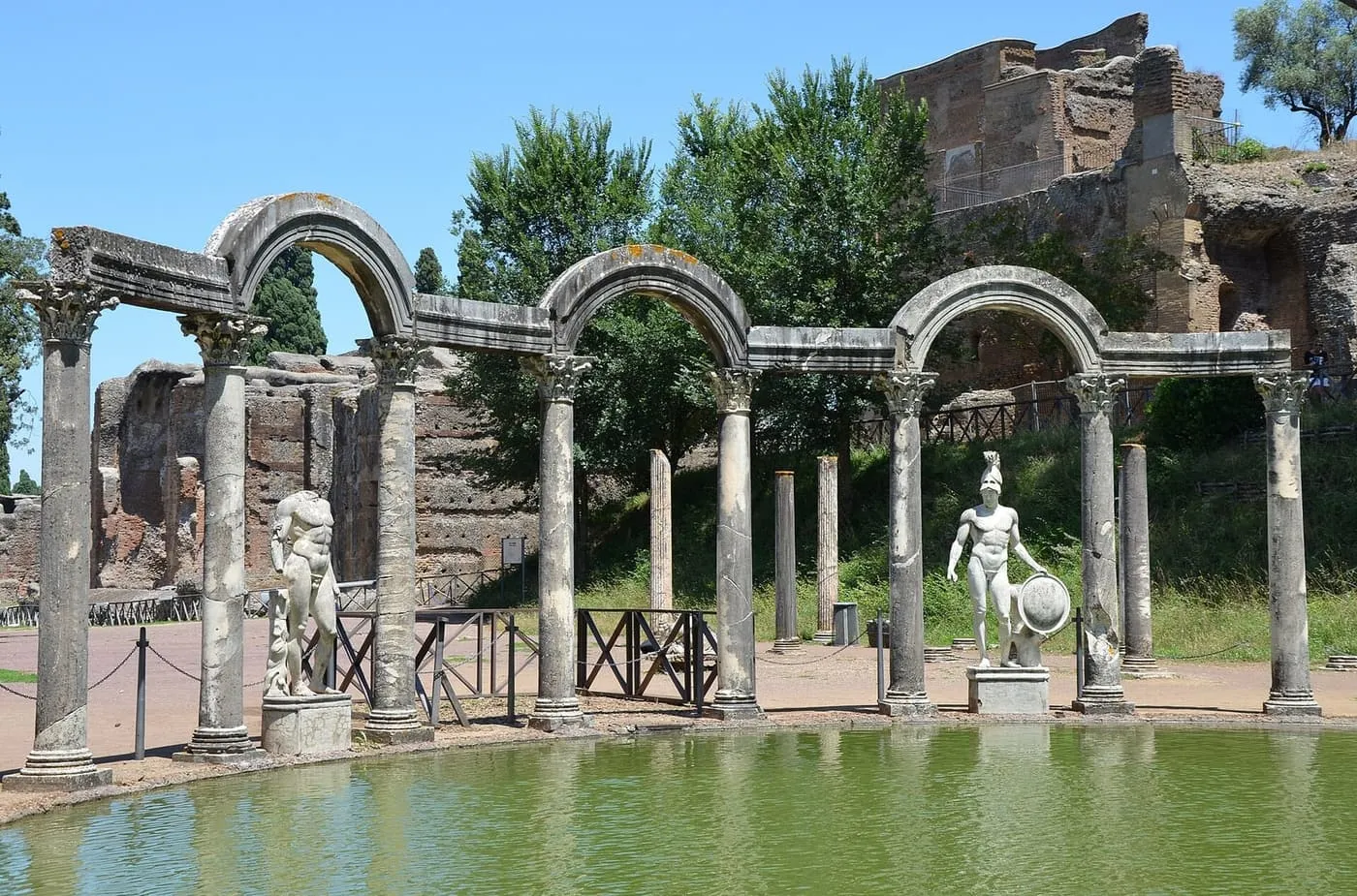 The Canopus pool at Hadrian's Villa, with a row of columns and arches and marble statues along its edge