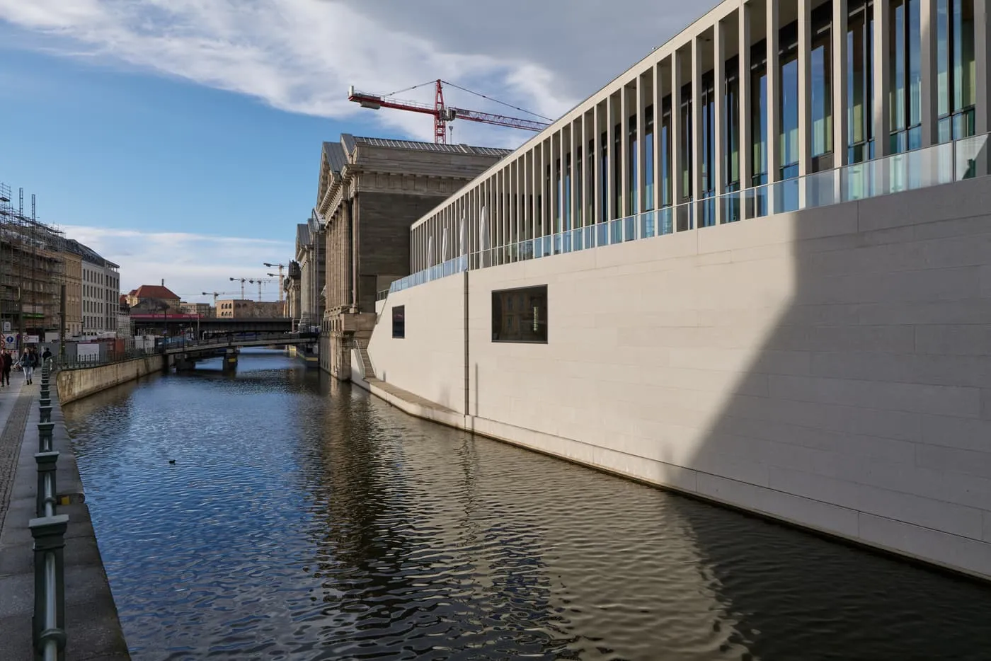 The long colonnaded front of the James-Simon-Galerie rising from the Kupfergraben canal, with the Pergamonmuseum behind it