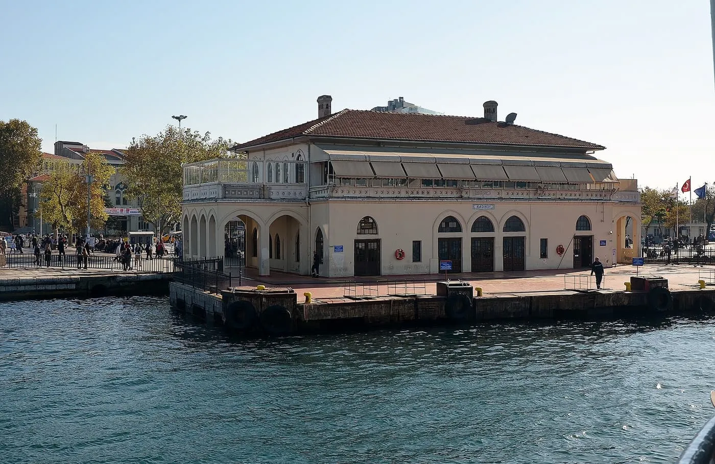 The old ferry pier building at Kadıköy, a two-storey stone terminal with arched doorways on a floating landing stage