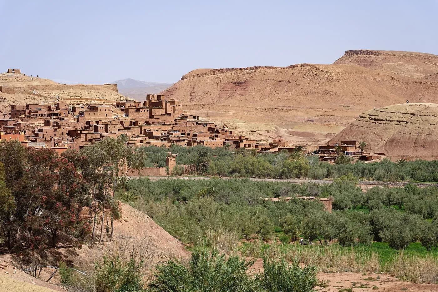 The earthen ksar of Aït Benhaddou on its hillside across a green valley
