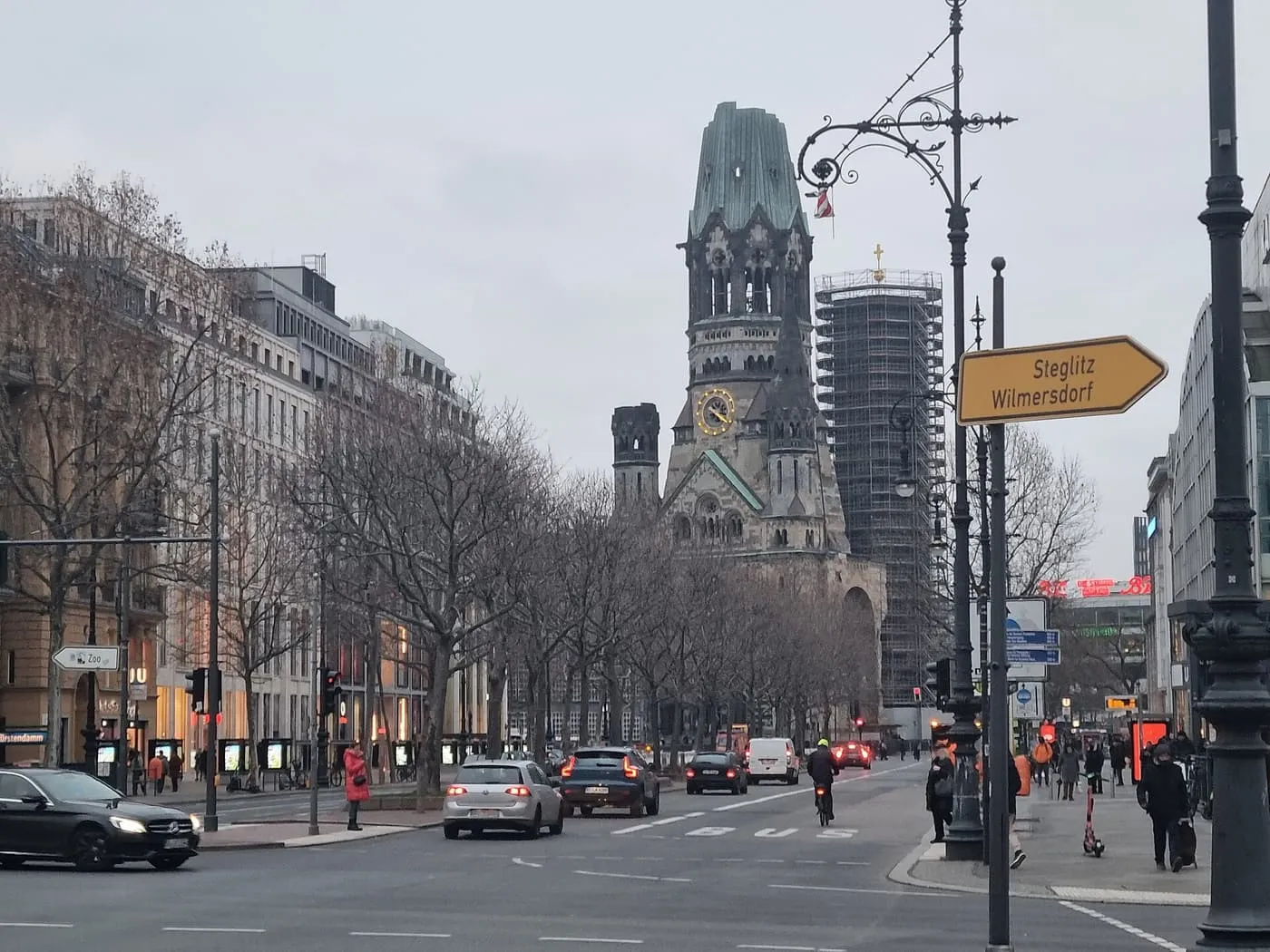 The Kurfürstendamm lined with bare trees, with the tower of the Kaiser Wilhelm Memorial Church ahead