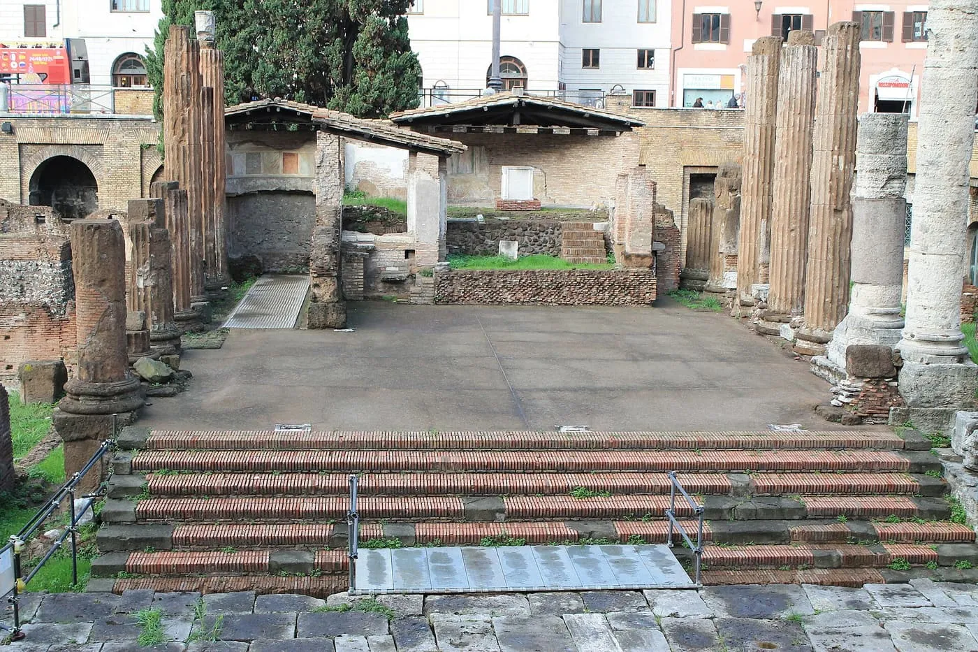 The brick steps of one of the Republican temples at Largo Argentina, with fluted columns and a tiled roof over the remains of the cella
