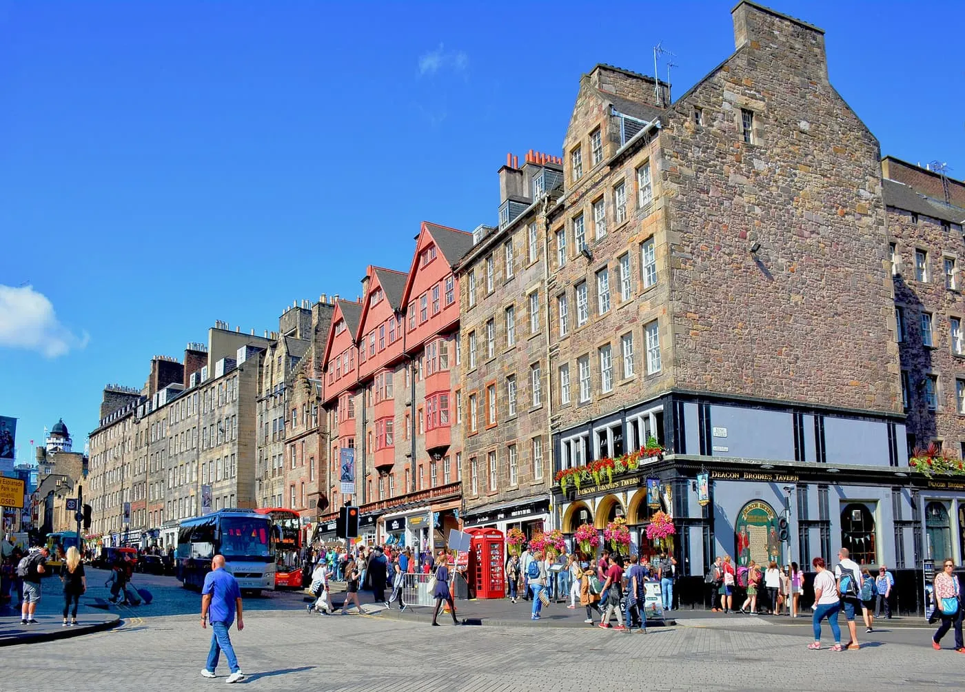 The Lawnmarket stretch of the Royal Mile, a cobbled junction lined with tall stone tenements and buses passing