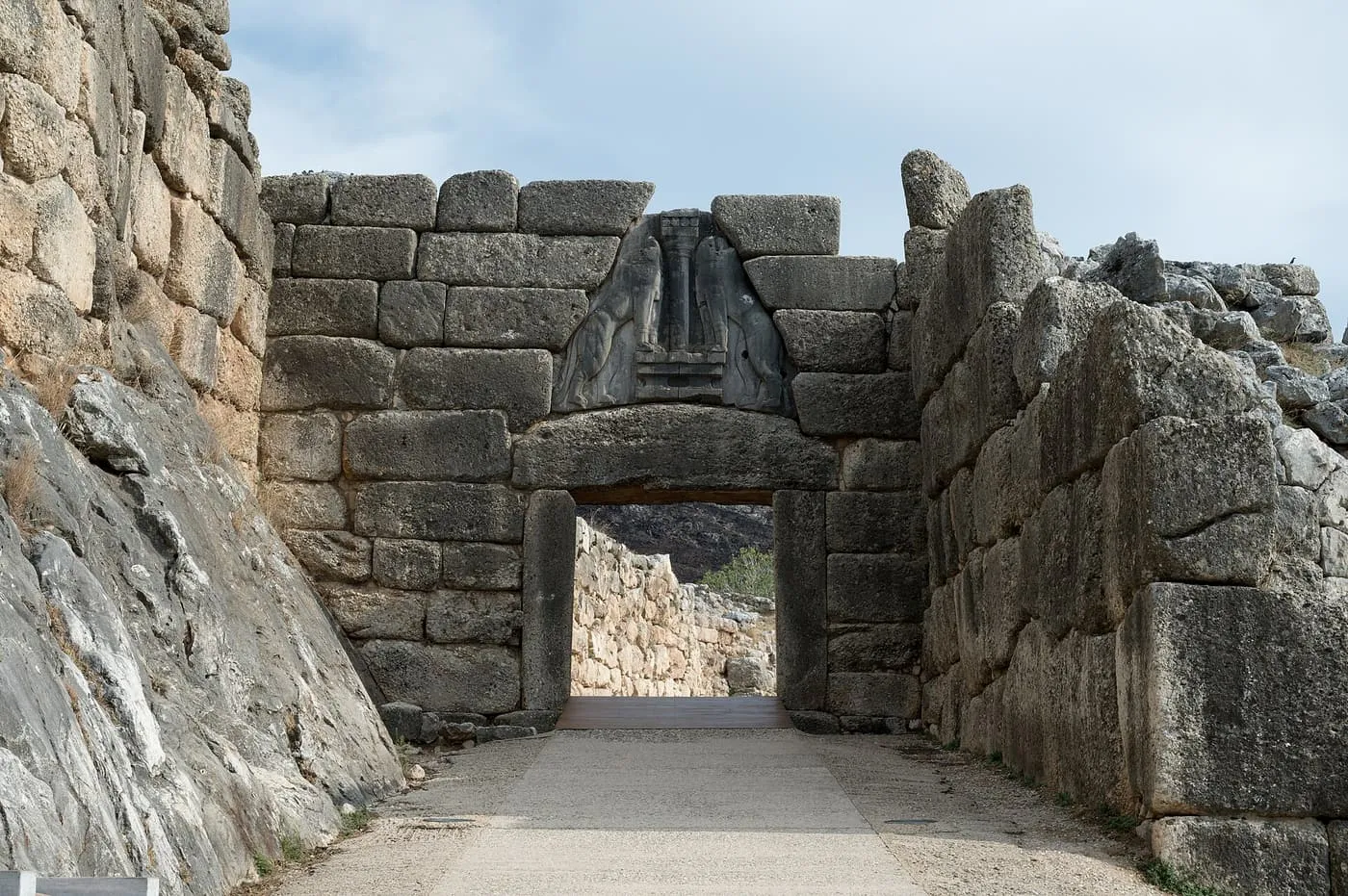 The Lion Gate at Mycenae, a stone doorway under a triangular slab carved with two lions either side of a column, between massive stone walls