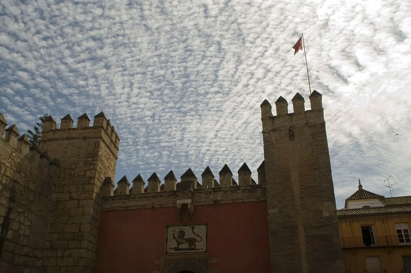 The Lion Gate in the Alcázar's crenellated walls, with a tiled lion above the arch