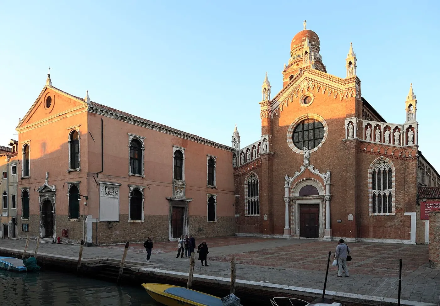 The brick Gothic front of Madonna dell'Orto, with a round window and white stone pinnacles