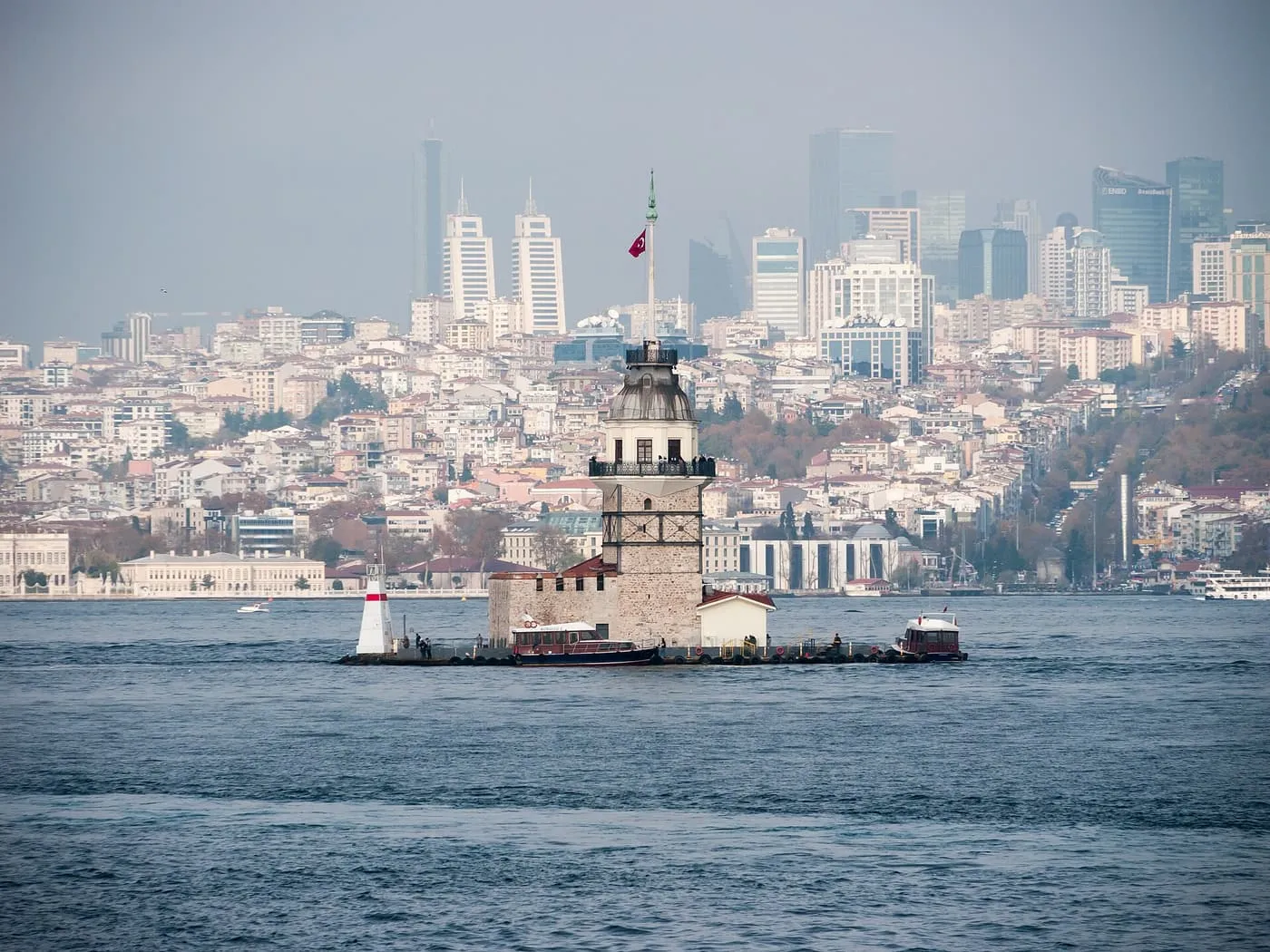 The Maiden's Tower on its small rock in the Bosphorus, with the shore and tall buildings behind it
