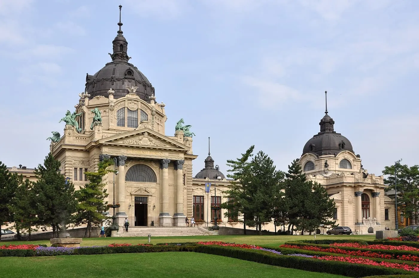 The domed main entrance building of the Széchenyi Baths seen across formal flower beds in the City Park