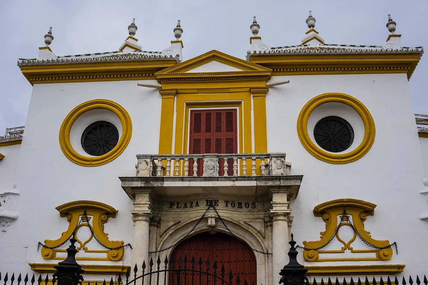 The white and yellow front of the Maestranza, with the words Plaza de Toros above a red arched door