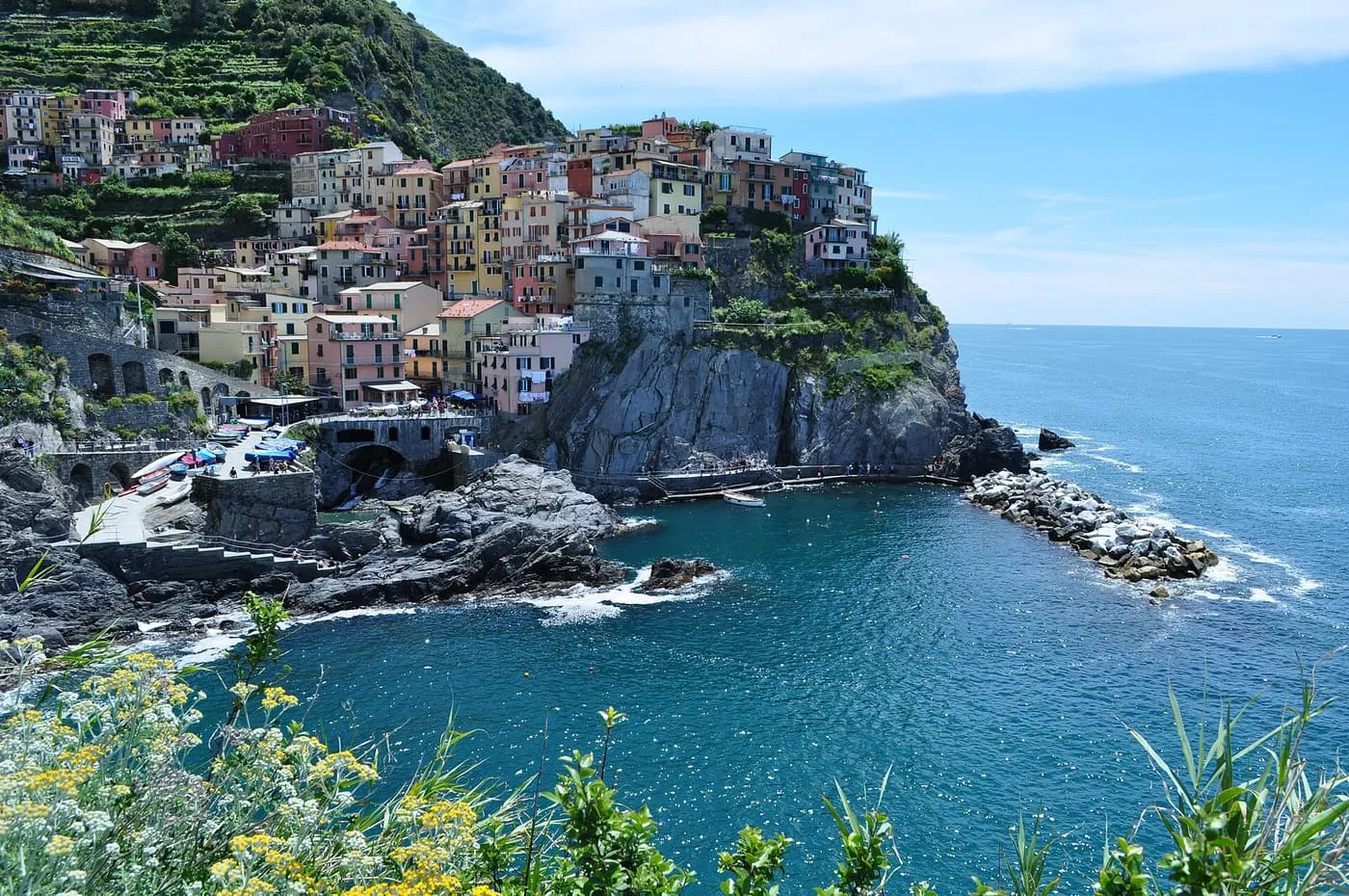 Pastel houses of Manarola stacked on a rocky headland above a small harbour