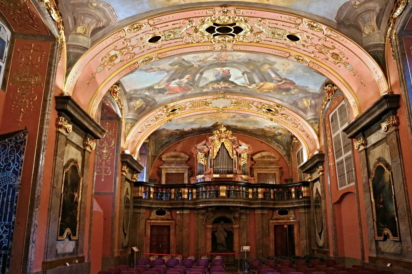 The Mirror Chapel in the Clementinum, with its painted and gilded vault, the organ loft and rows of seats for a concert