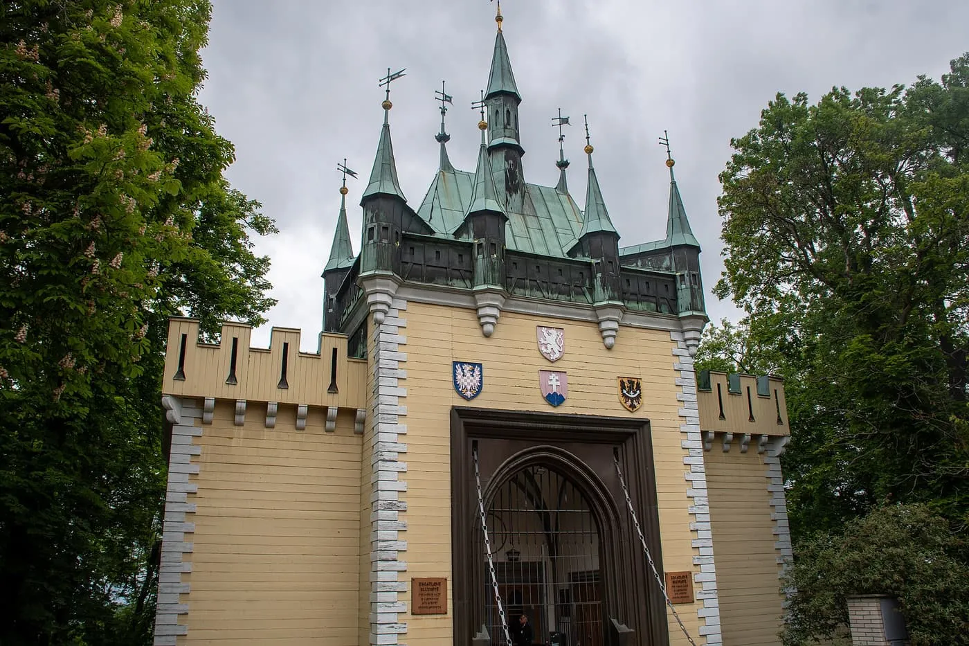 The small castle-like building of the Mirror Maze on Petřín, with a crenellated front, green copper turrets and a gateway