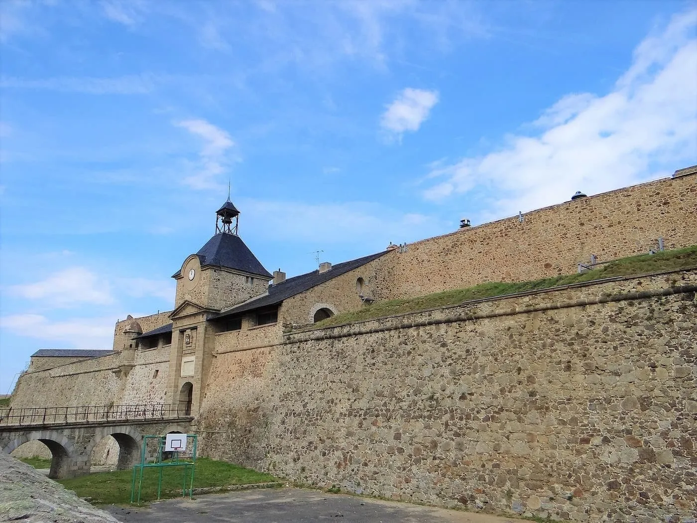 The gatehouse of the citadel at Mont-Louis, with a clock tower and bell above thick stone ramparts