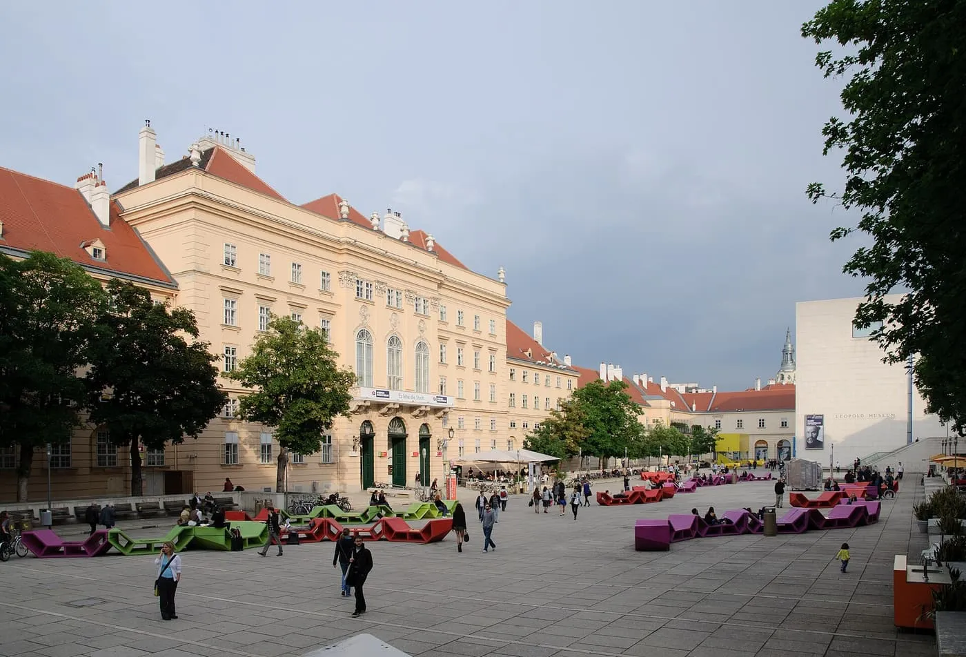 The MuseumsQuartier courtyard, a wide paved square with coloured loungers in front of the former imperial stables