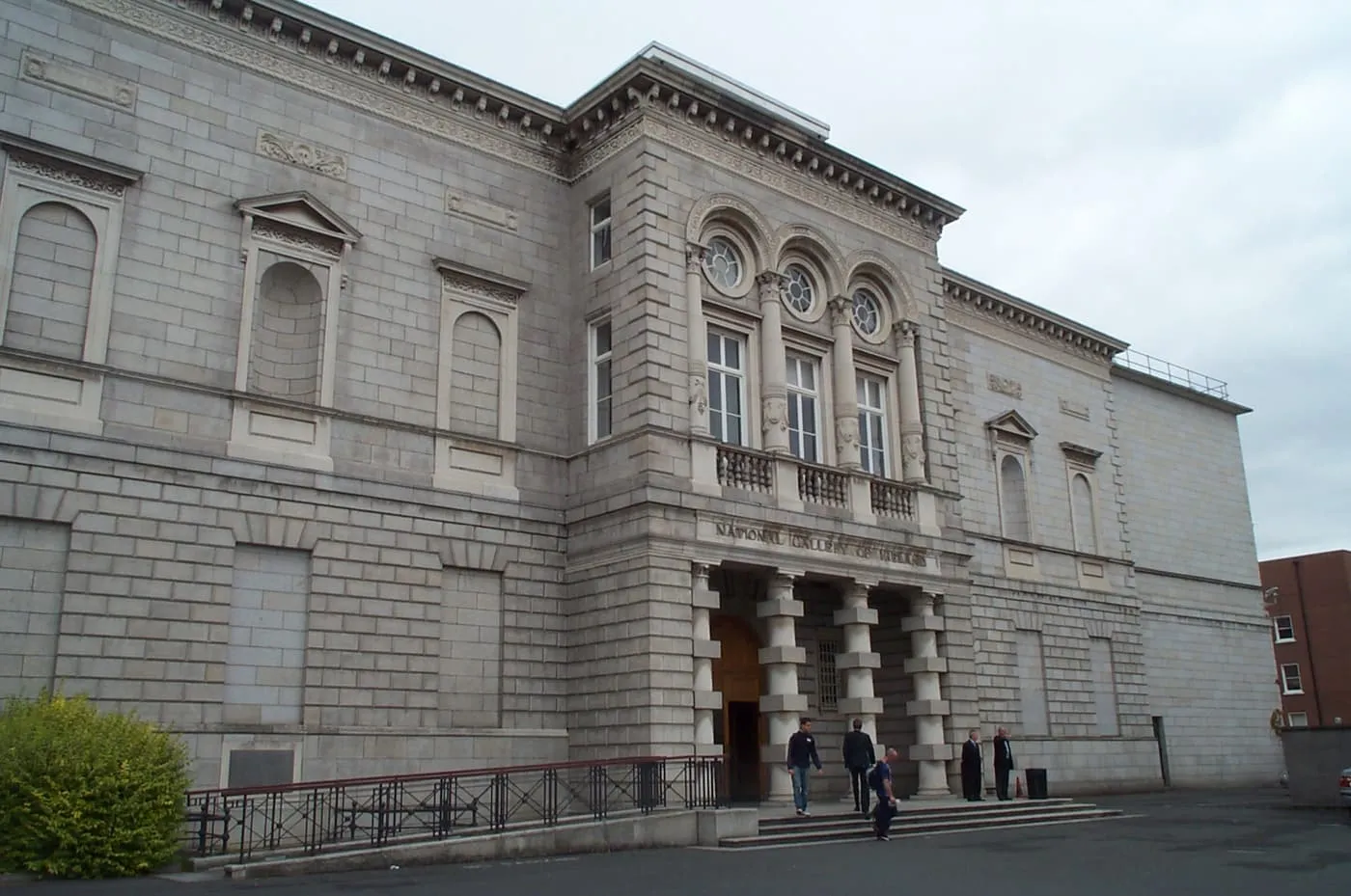 The grey stone front of the National Gallery of Ireland with a columned entrance porch and steps