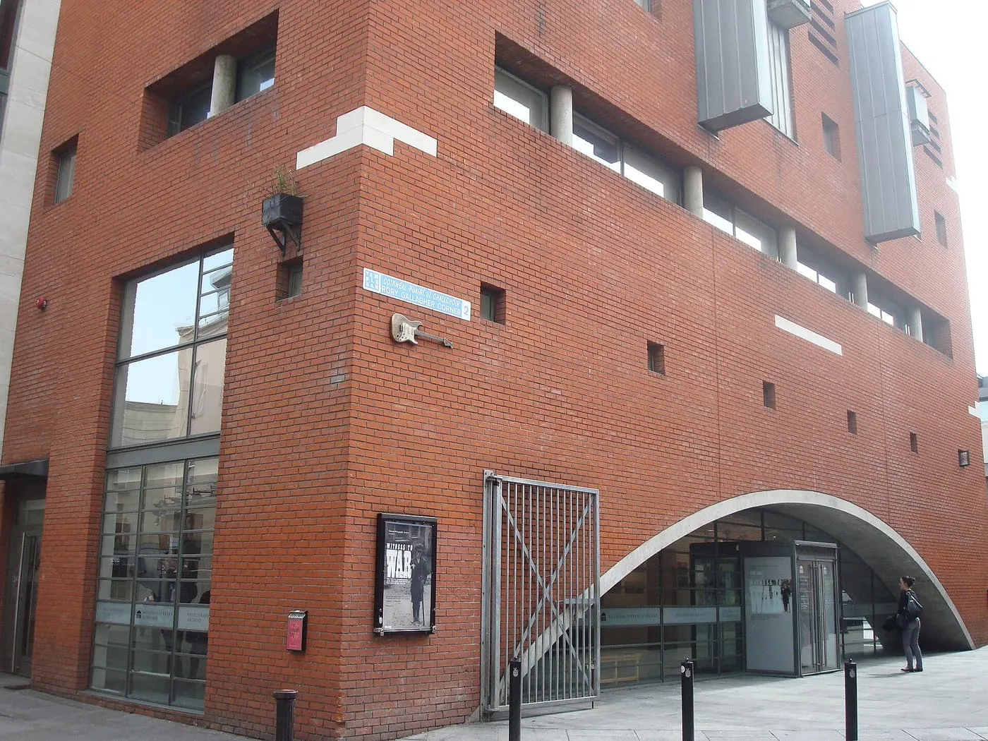 The red-brick corner of the National Photographic Archive with a curved concrete entrance arch
