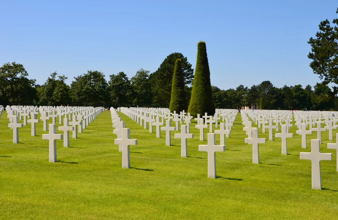 Rows of white marble crosses and Stars of David on the lawns of the Normandy American Cemetery