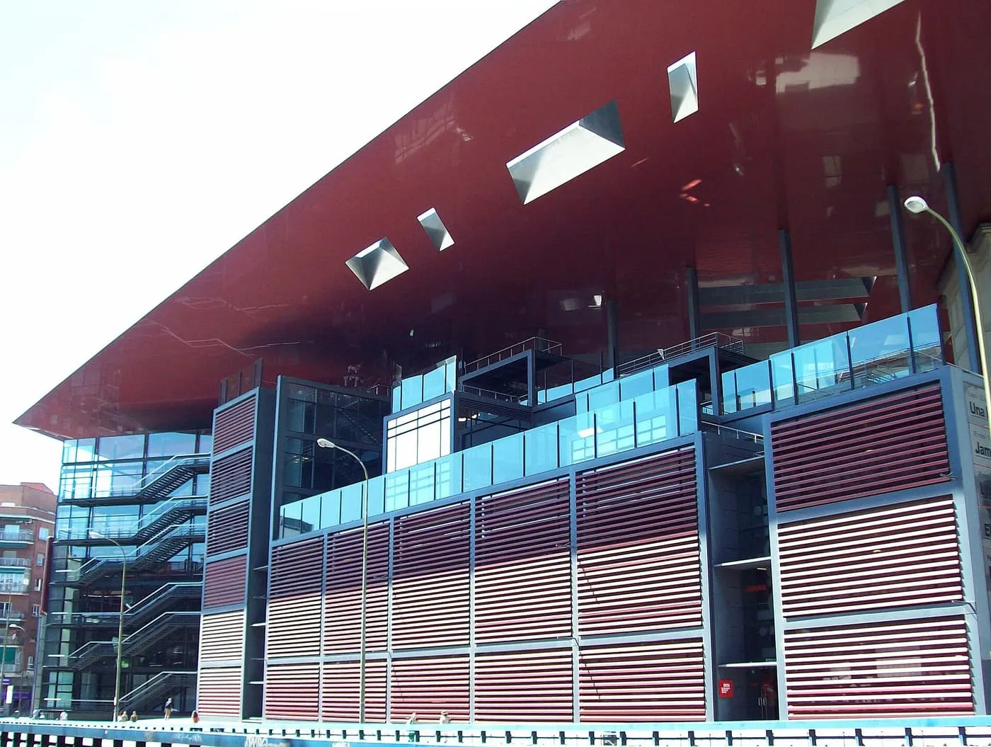 The Nouvel extension of the Reina Sofía, with its glass and red-slatted walls under a large glossy red roof