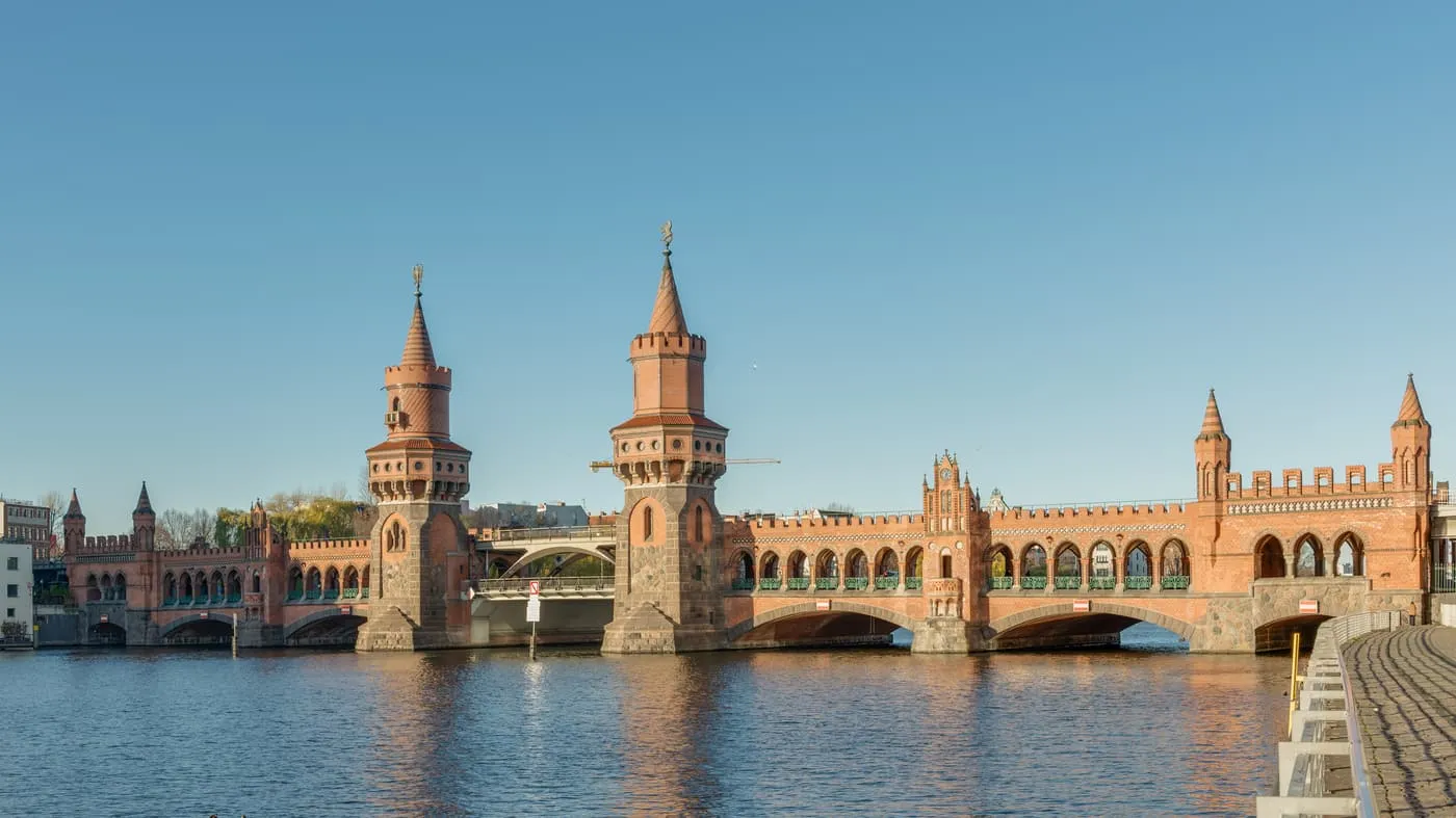 The Oberbaumbrücke over the Spree, with its brick towers and arcaded upper deck, under a clear sky
