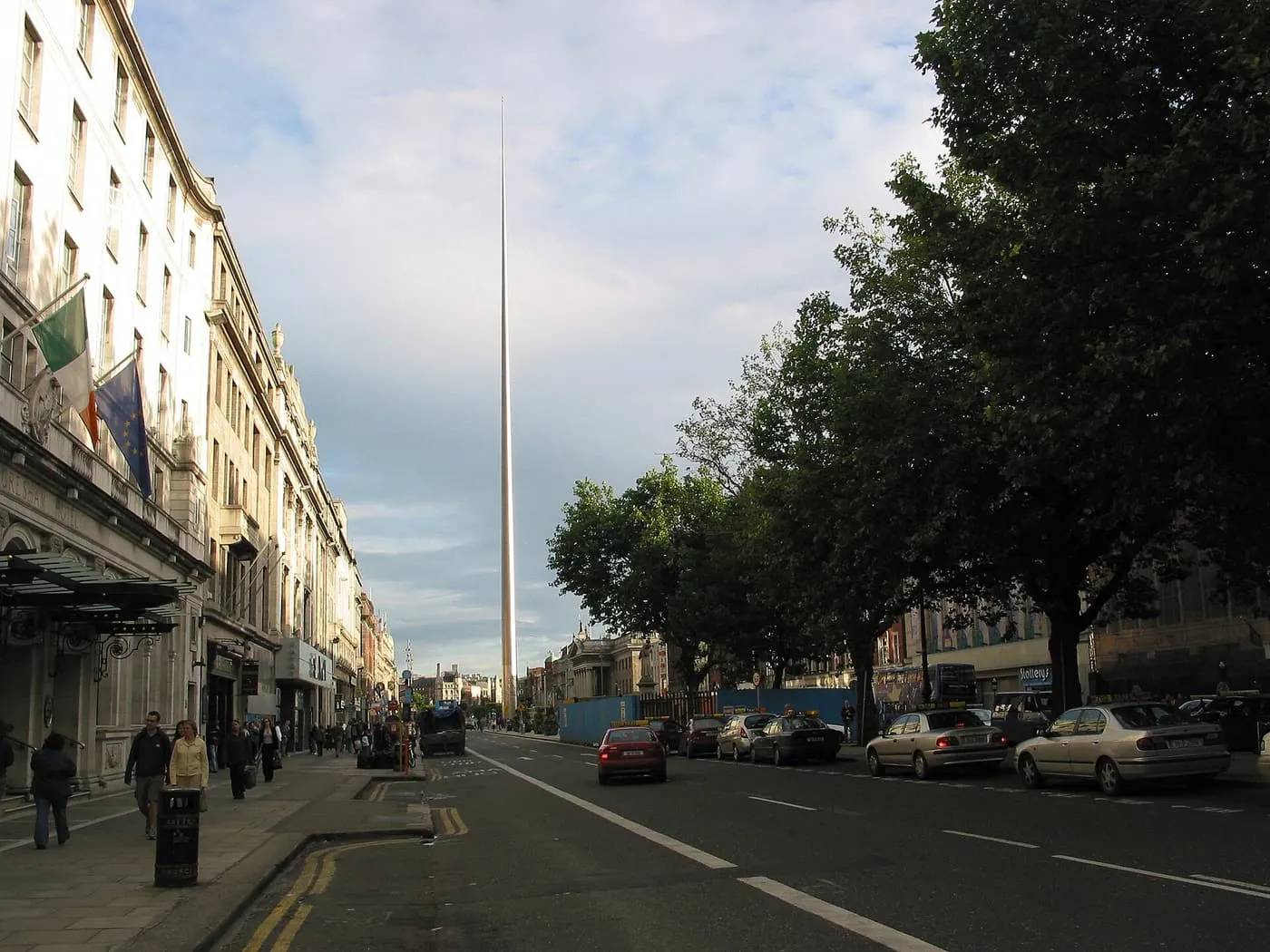 The Spire rising above O'Connell Street, with hotels on the left and plane trees on the right