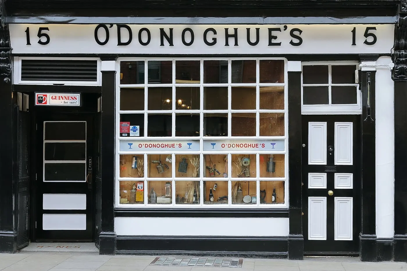 The black-and-white painted front of O'Donoghue's pub on Merrion Row, with a sash window display and the number 15 on the fascia