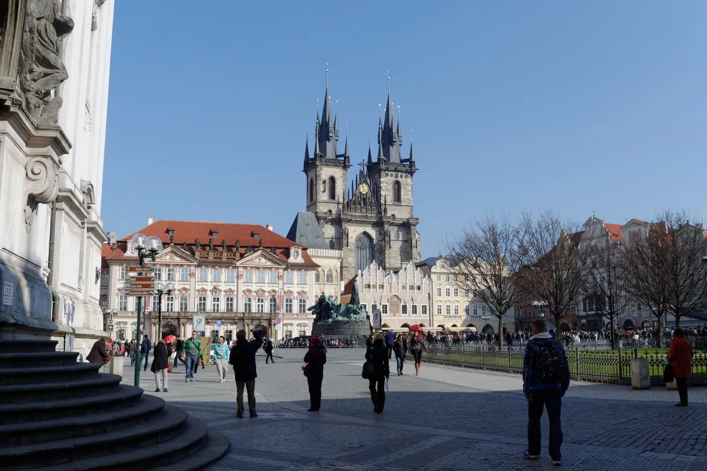 The twin towers of the Church of Our Lady before Týn rising behind the Kinský Palace and the Jan Hus Memorial on Old Town Square