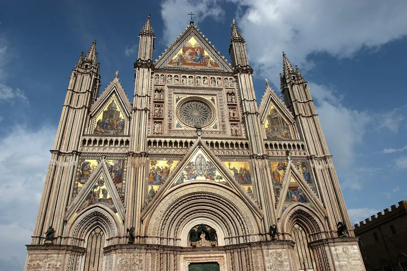 The gold mosaics, rose window and Gothic spires of Orvieto Cathedral's facade
