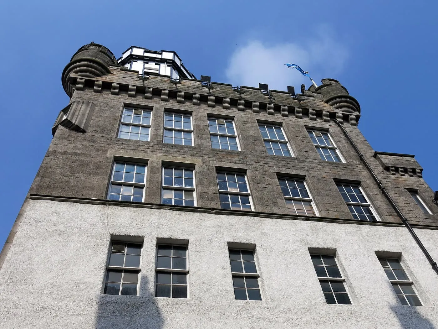 The stone Outlook Tower on Castlehill from below, with its corner turrets and the glazed camera chamber on top