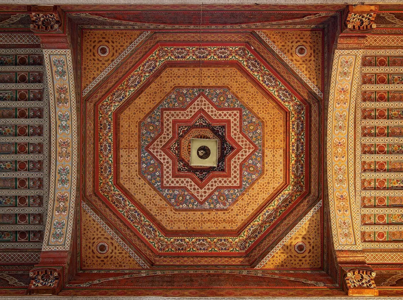 A painted wooden ceiling in the Bahia Palace, with an octagonal centre in red, gold and blue
