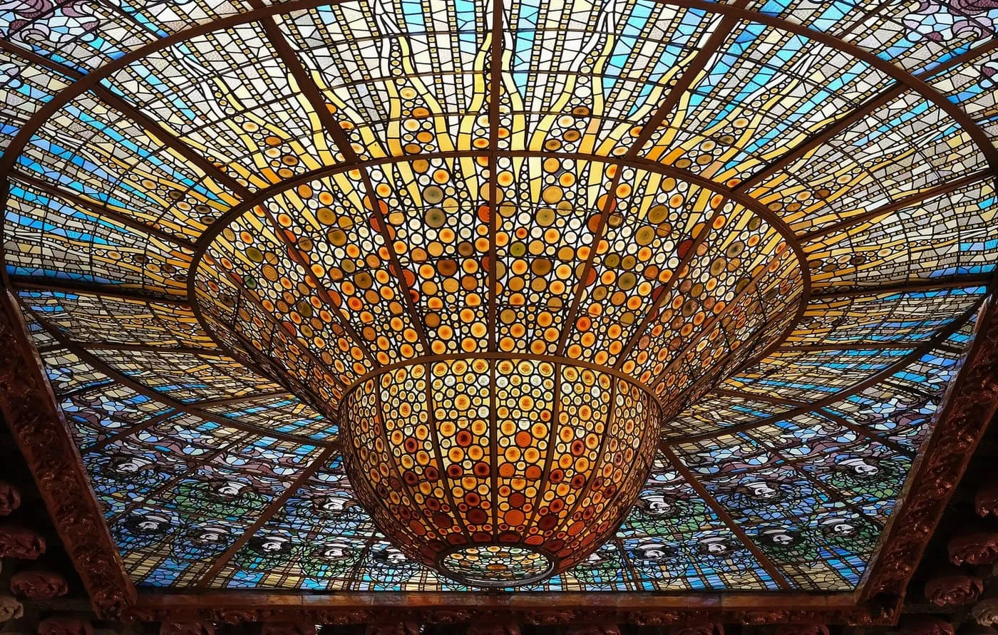 The stained-glass skylight of the concert hall, a sunburst of amber and blue glass roundels