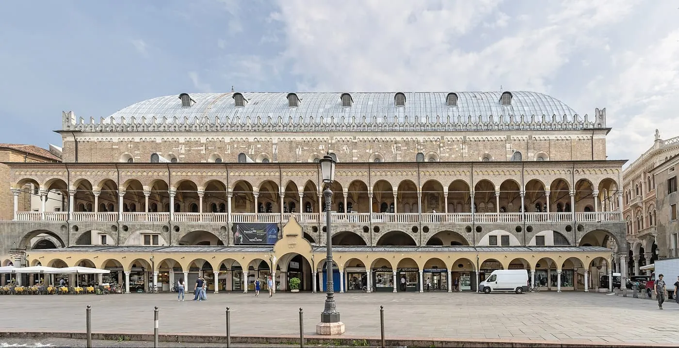 The long façade of the Palazzo della Ragione in Padua: an arcaded ground floor, an open loggia above and a curved metal roof