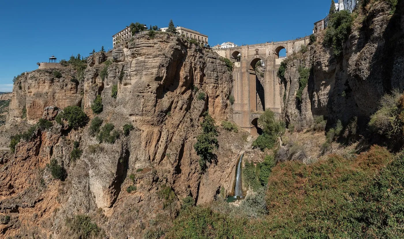 The Puente Nuevo crossing the El Tajo gorge at Ronda, with a waterfall below, the sandstone cliffs and the Parador on the rim