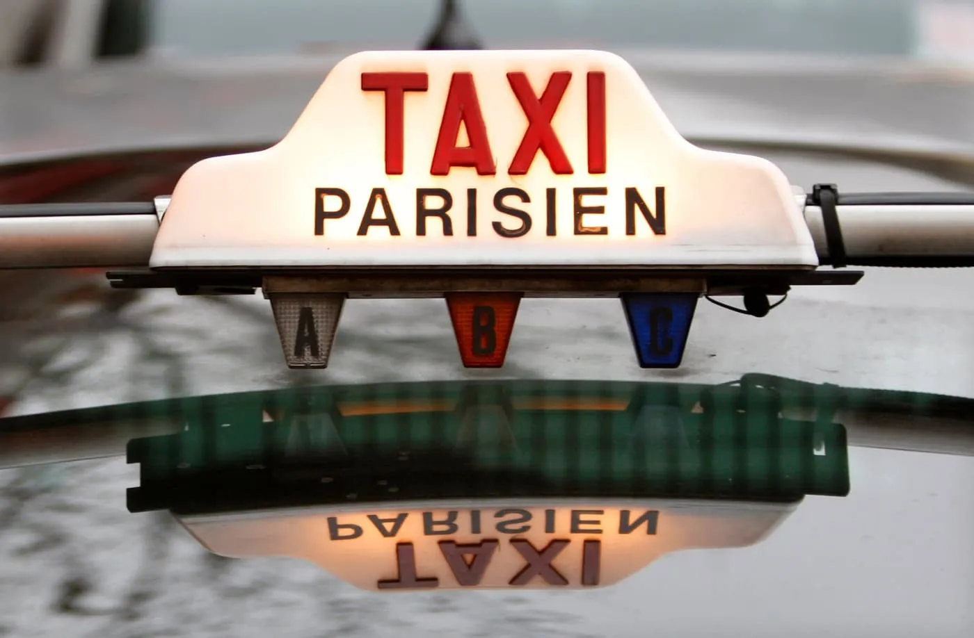 Lit "Taxi Parisien" roof sign on a Paris taxi
