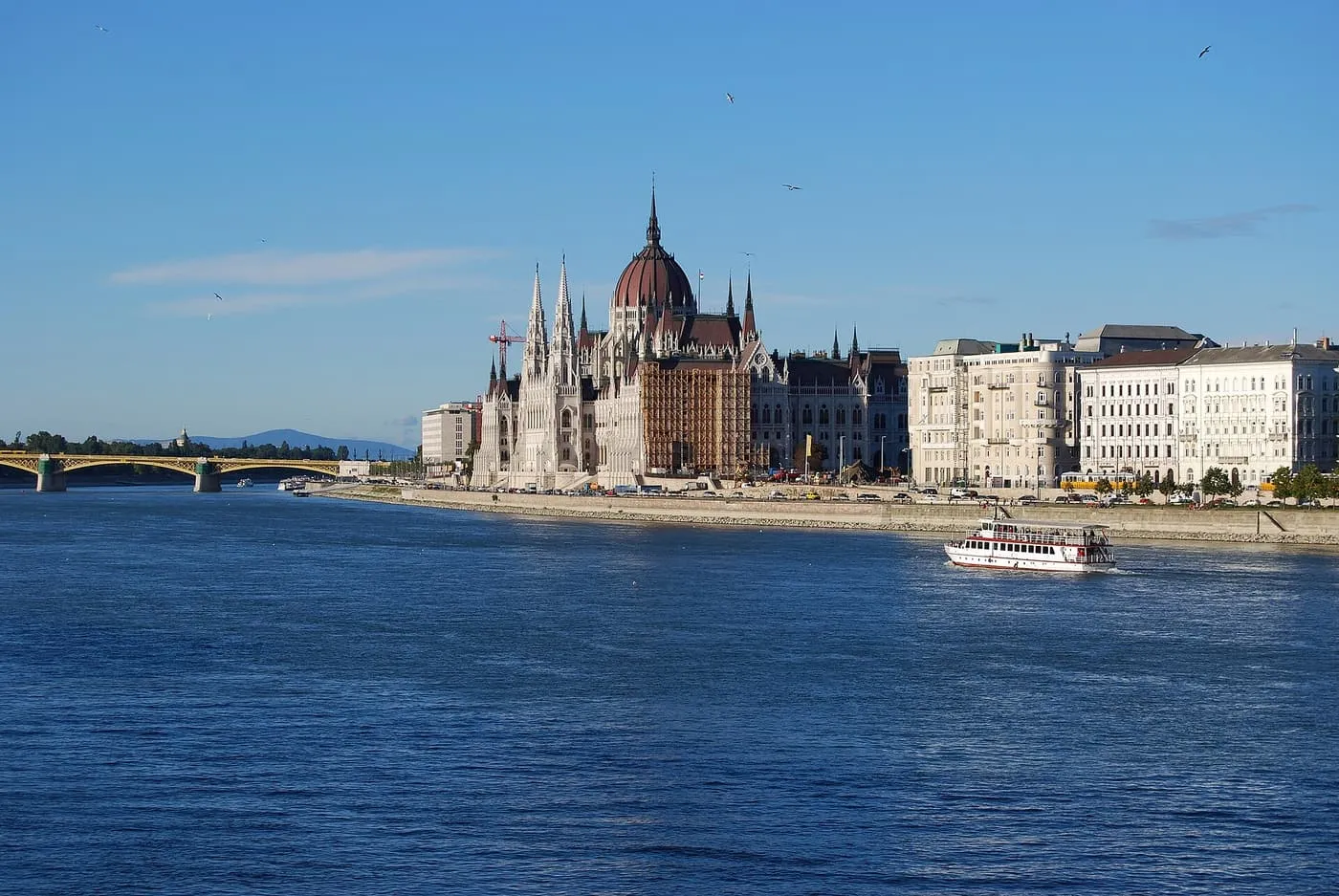 The Hungarian Parliament on the Pest bank of the Danube, with Margaret Bridge beyond and a river boat in front