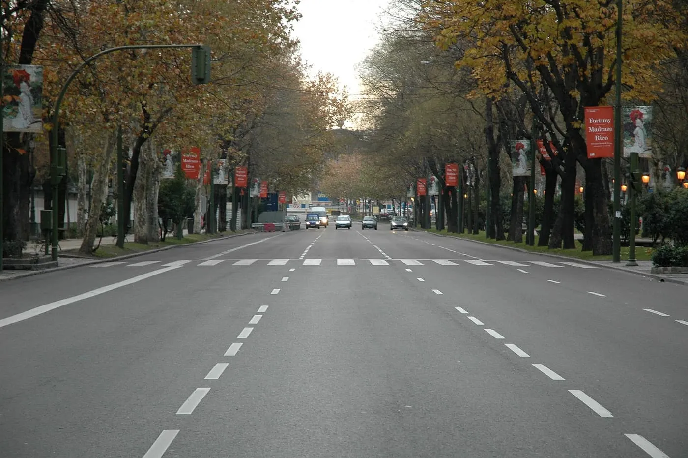 The Paseo del Prado, a wide avenue lined with trees in autumn colour, looking along the traffic lanes