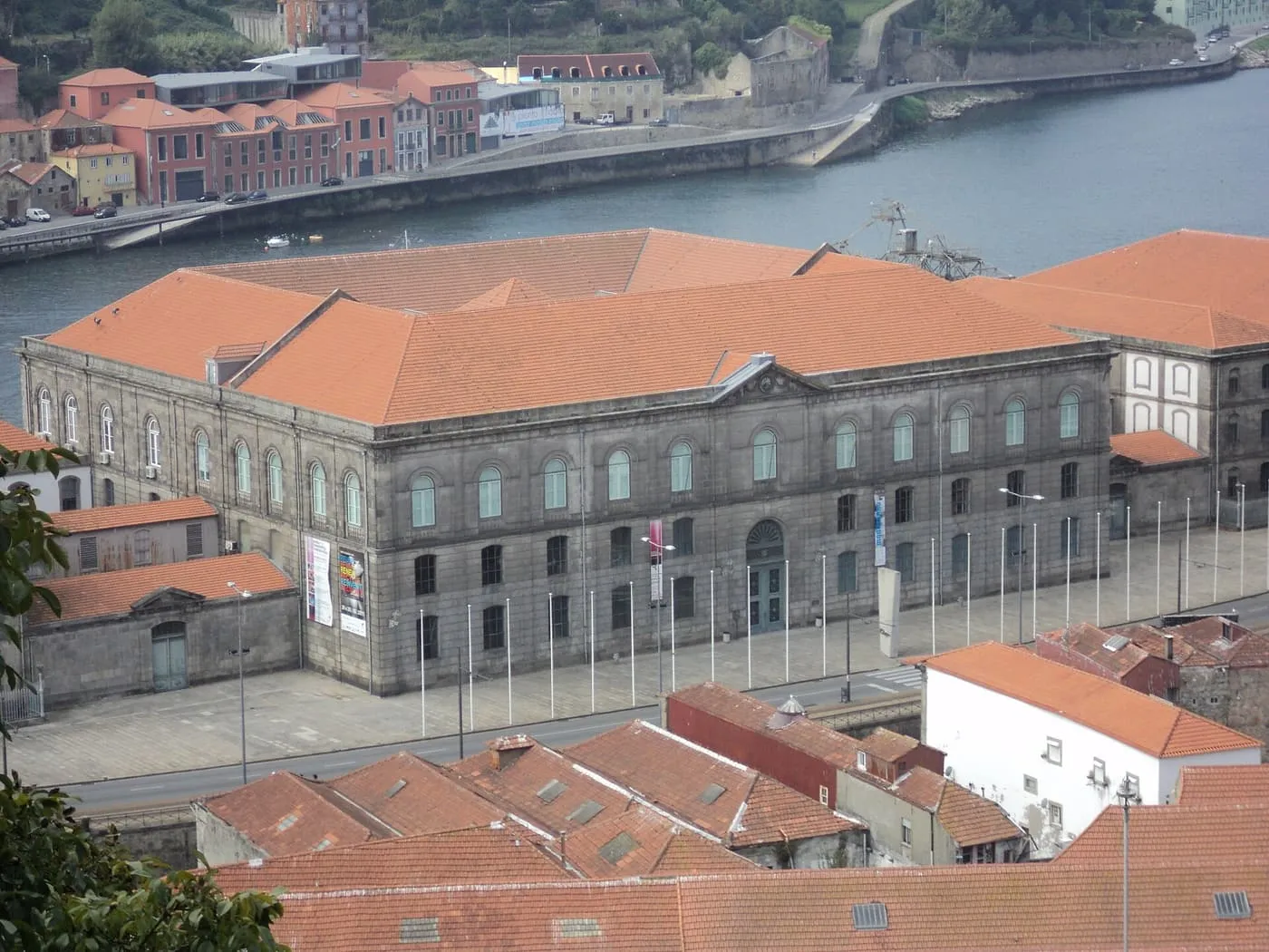 The long granite former Customs House on the Douro waterfront below Passeio das Virtudes, with red roofs around it