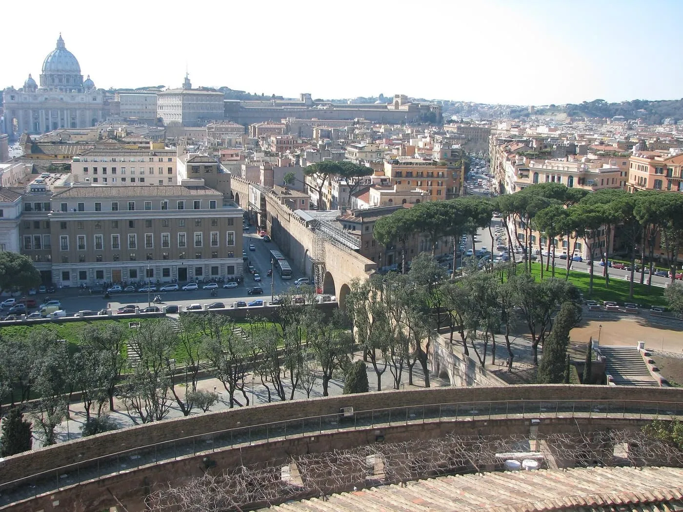 The arched wall of the Passetto di Borgo running through the trees and rooftops towards St Peter's Basilica