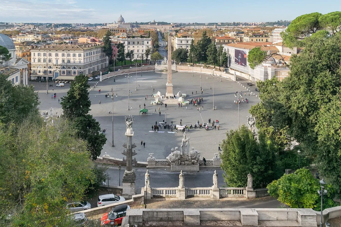 Piazza del Popolo seen from the Pincio terrace, an oval square with the obelisk at its centre and the dome of St Peter's on the horizon