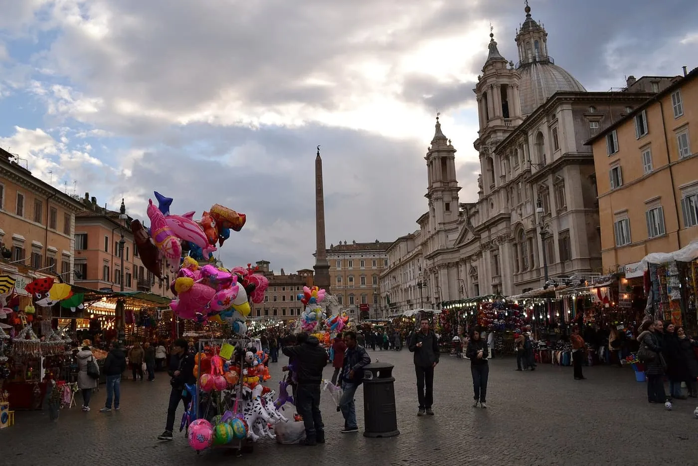 Balloon sellers and Christmas fair stalls in Piazza Navona, with the obelisk and the church of Sant'Agnese in Agone on the right