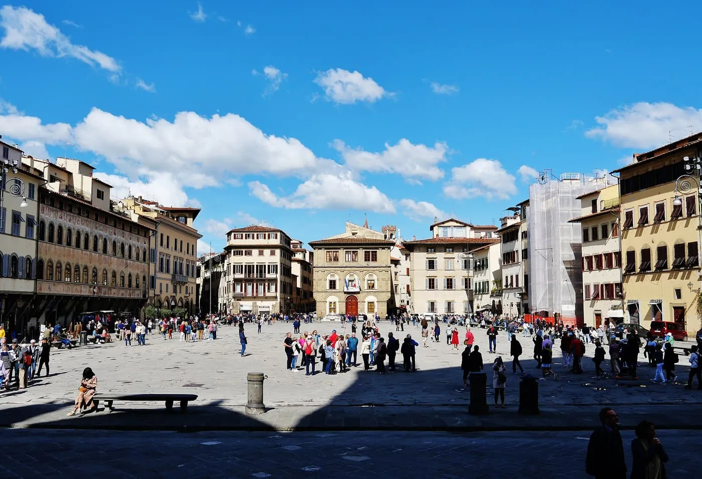 Piazza Santa Croce under a blue sky, with the palaces along its far side and visitors crossing the square