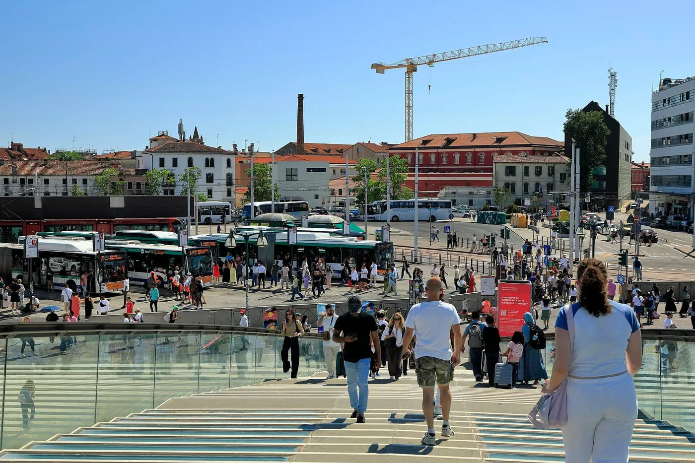 Passengers on the steps above Piazzale Roma, looking over the bus terminal and the rooftops beyond
