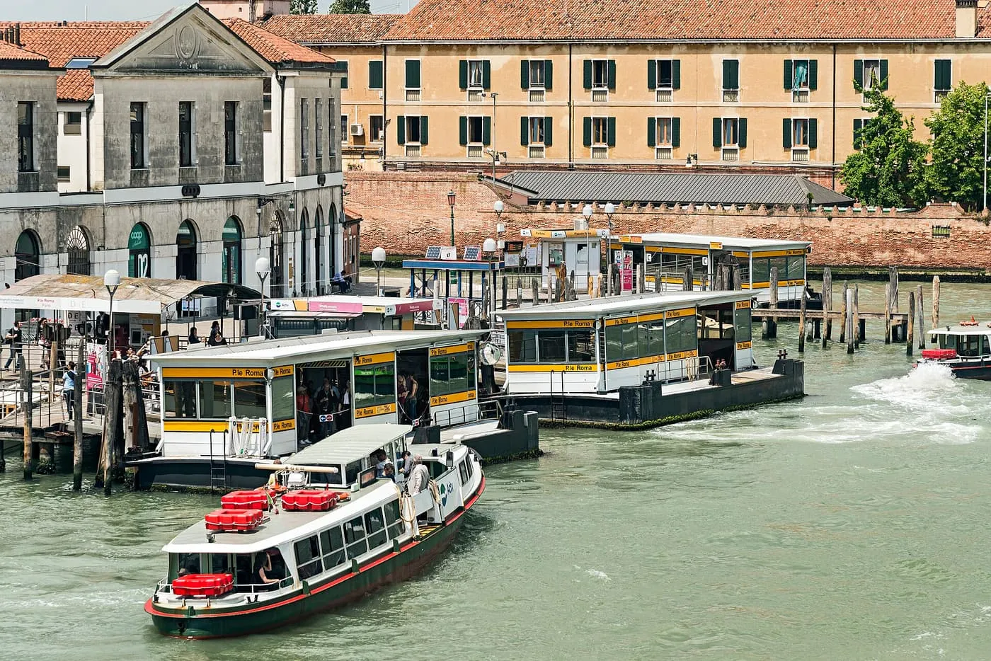 Vaporetto landing stages at Piazzale Roma on the Grand Canal, with a vaporetto arriving at the nearest stop