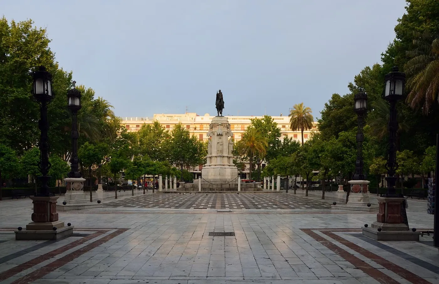 Plaza Nueva with its orange trees and iron lamp posts, and the equestrian statue of Ferdinand III at the far end