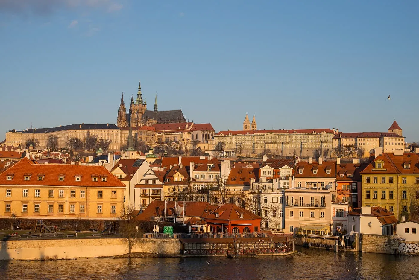 Prague Castle and the spires of St Vitus Cathedral above the roofs of Malá Strana, seen across the Vltava