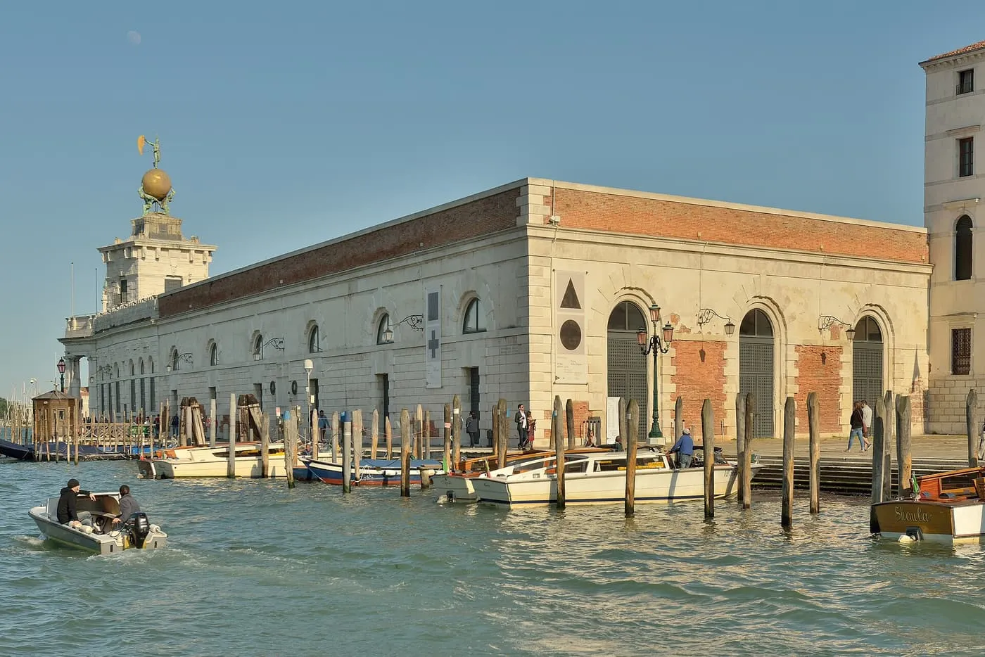 The long stone building of Punta della Dogana, with its tower and golden globe at the point
