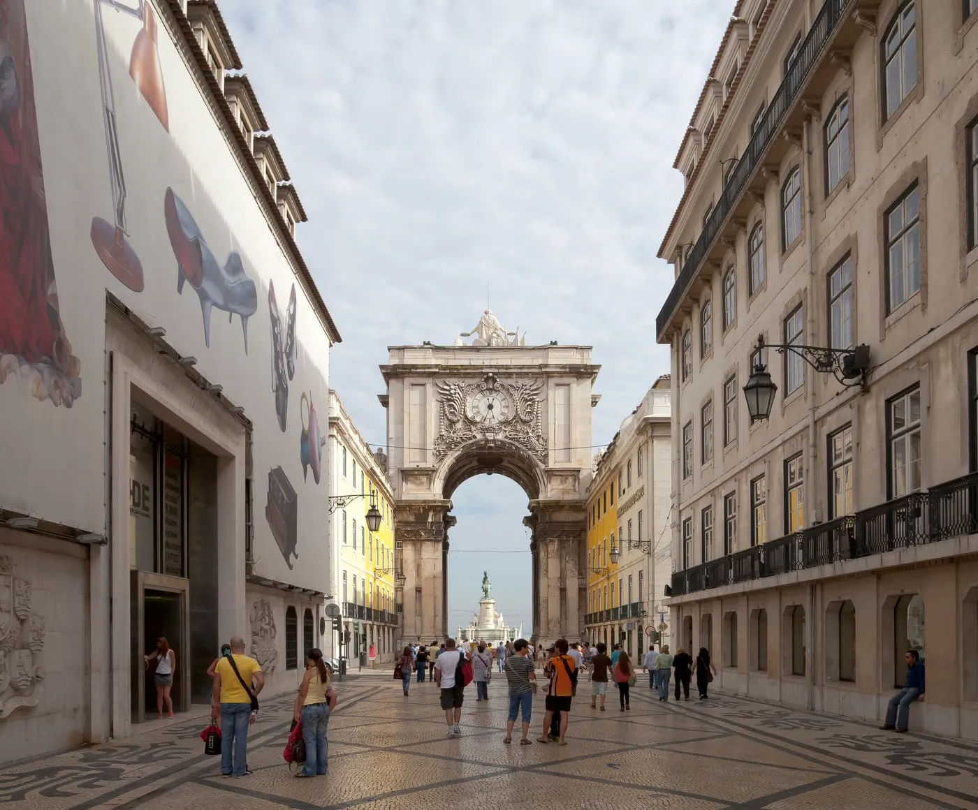 Rua Augusta, a pedestrian street paved in patterned stone, running to the Rua Augusta Arch at the far end under a cloudy sky