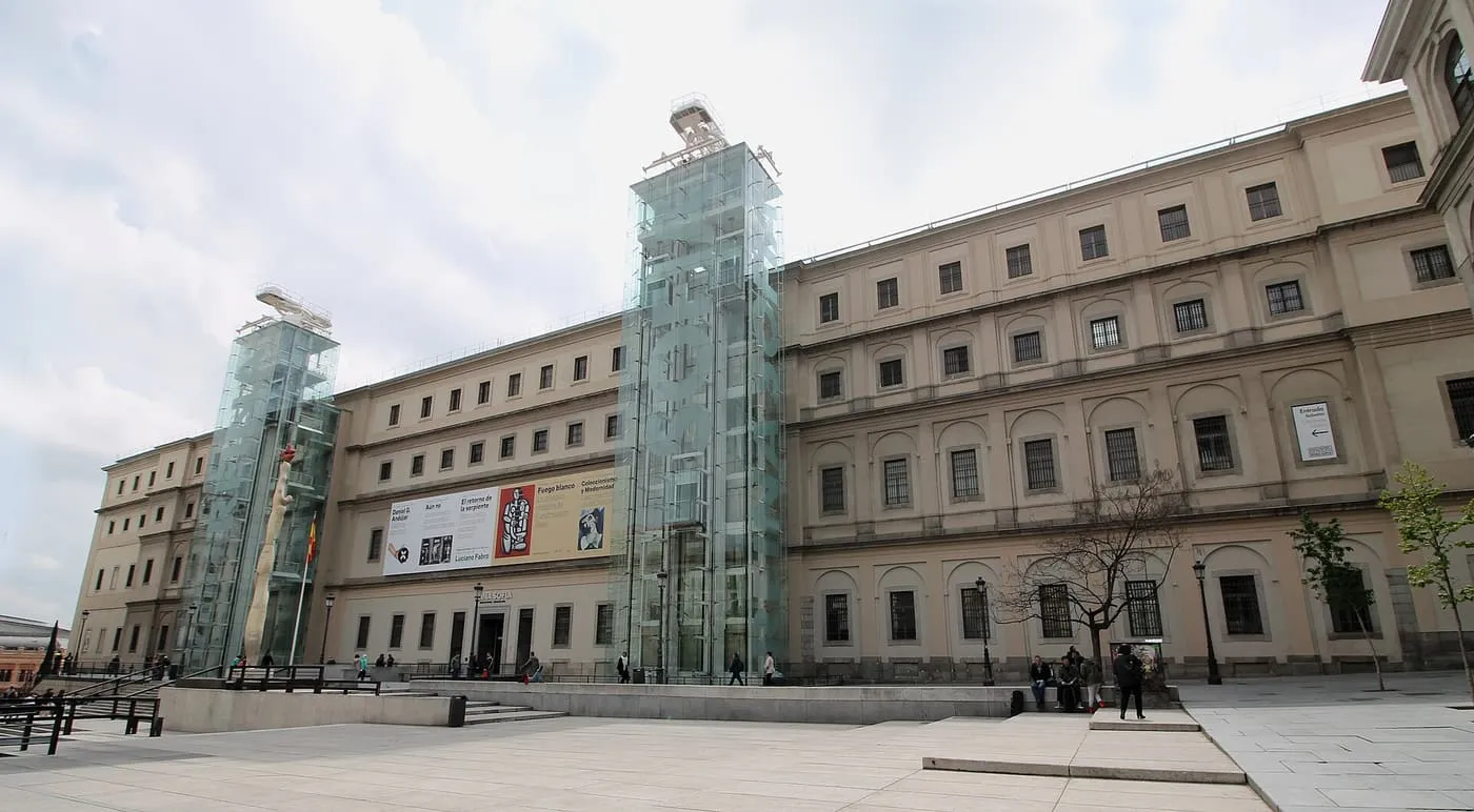 The long beige façade of the Sabatini Building of the Reina Sofía, with two glass lift towers rising above it