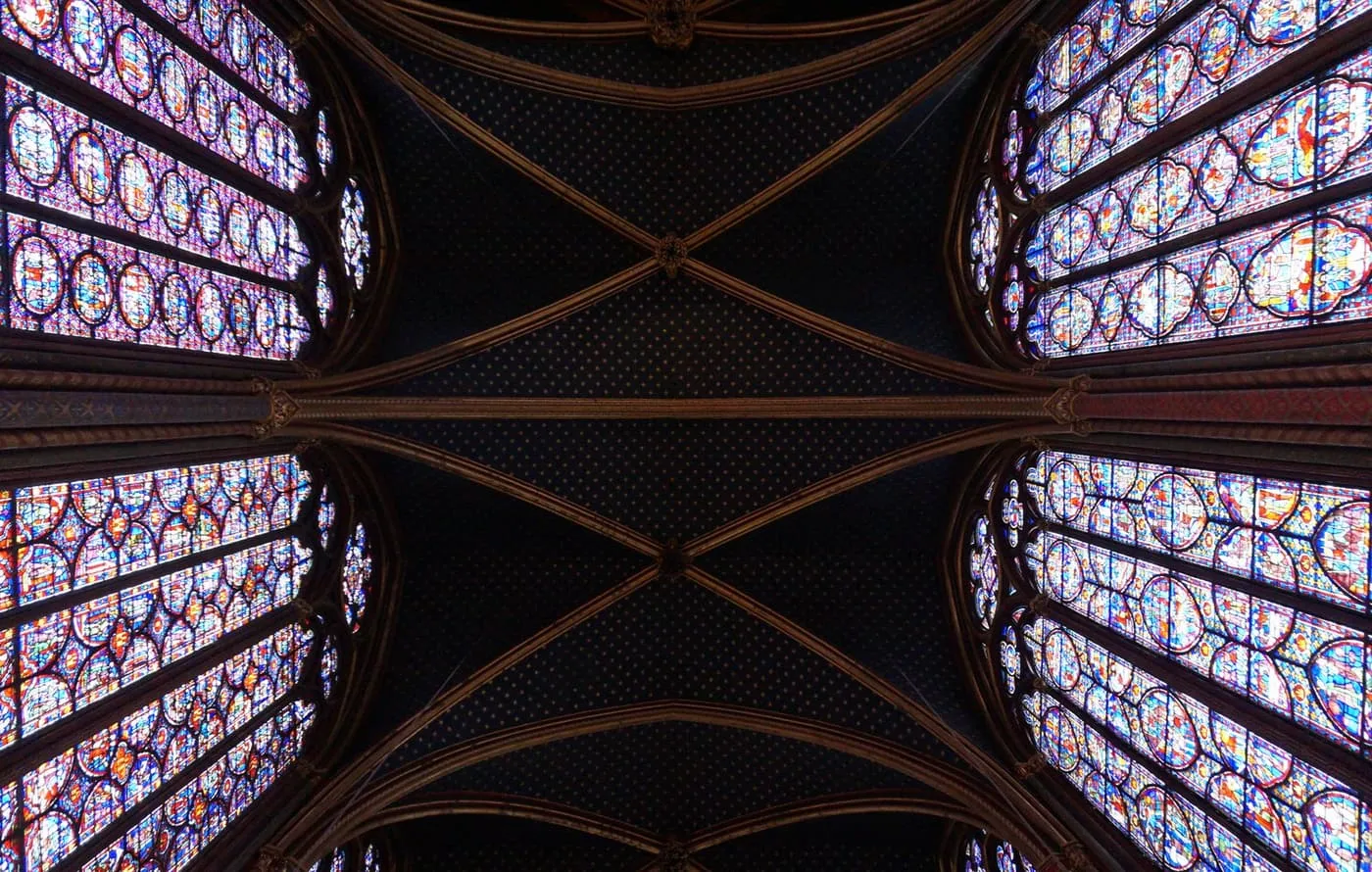 Looking up in the Sainte-Chapelle at the star-spangled blue vault between two walls of stained glass